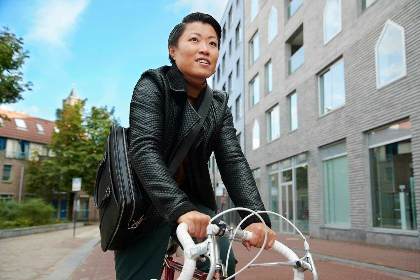 vrouw op fiets in stedelijke buurt met blauwe lucht